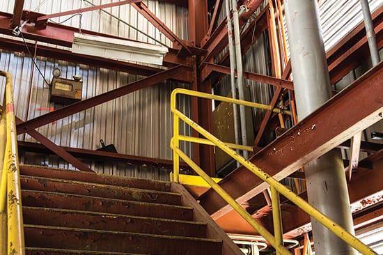 Sheet-metal-room-with-stairs-and-yellow-handrail